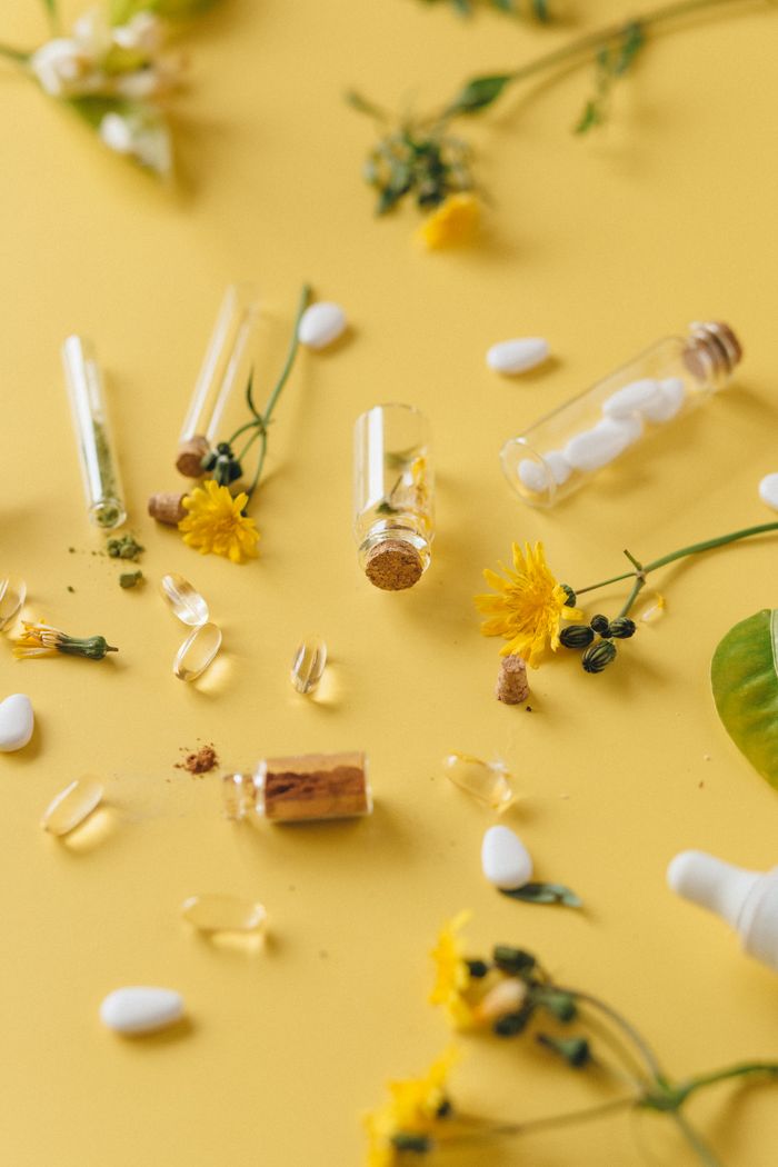 Home Aesthetic display of medicinal herbs and pharmaceutical capsules on a yellow background.